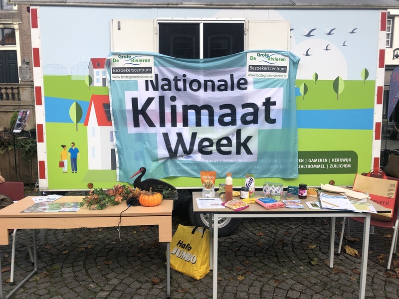 Keet met spandoek ervoor met Nationale Klimaatweek en tafels ervoor met folders, snoep, drinken en dergelijke